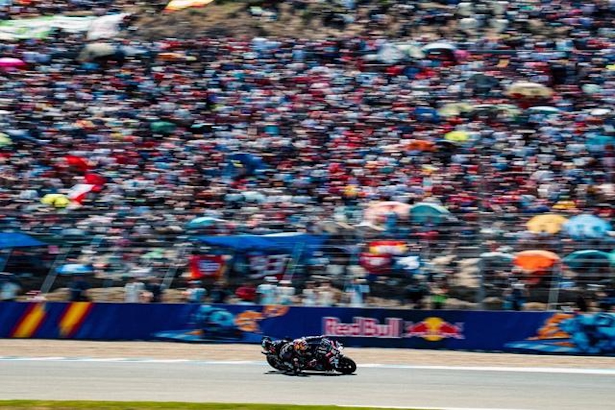 A packed Spanish grandstand watches an Aprilia rider sweep through Jerez at the 2026 MotoGP