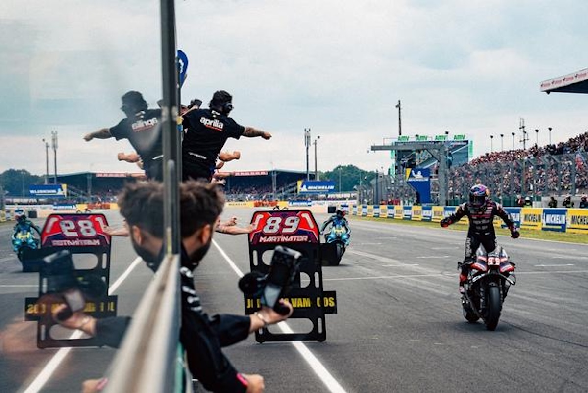 Jorge Martin rides back to the Aprilia pit after winning the 2026 French MotoGP at Le Mans, with crew raising MARTINATOR signs